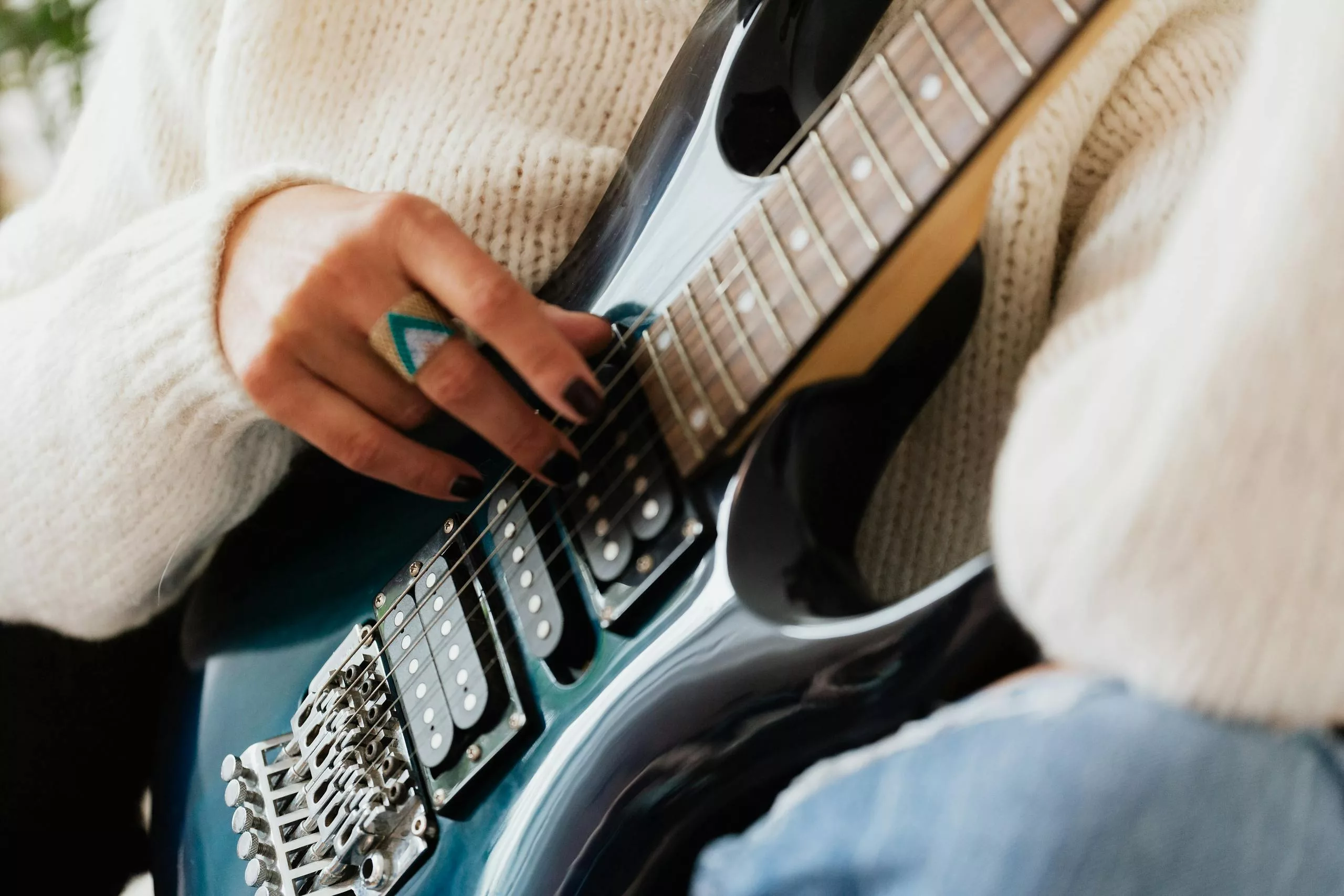 Woman strumming an electric guitar