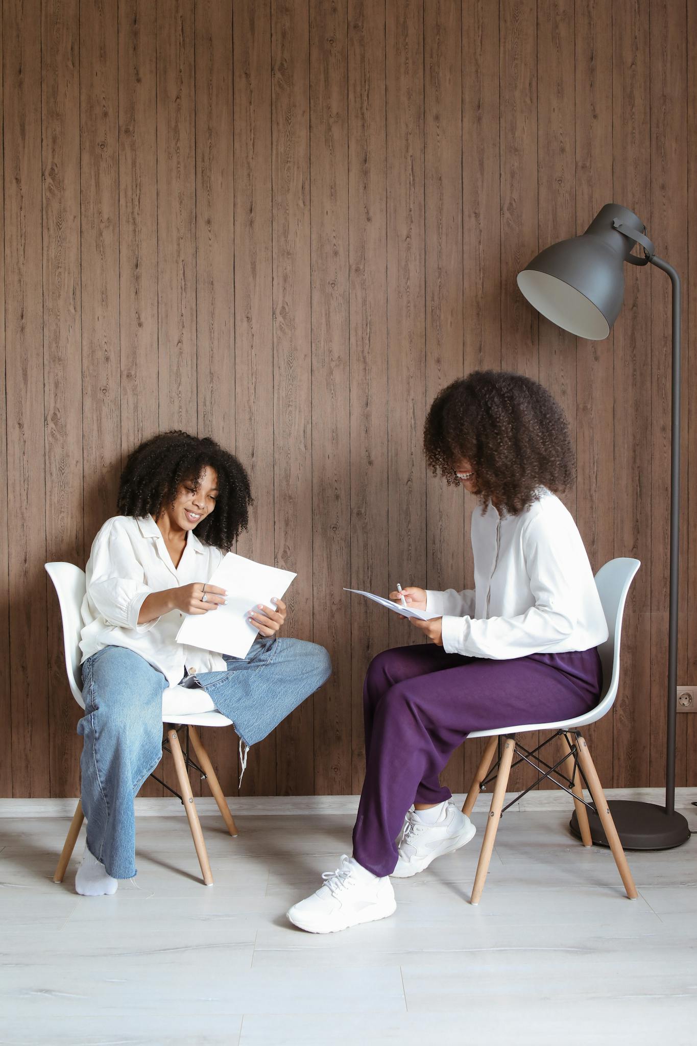 Two women engaging in a counseling session, seated in a modern, cozy office space.