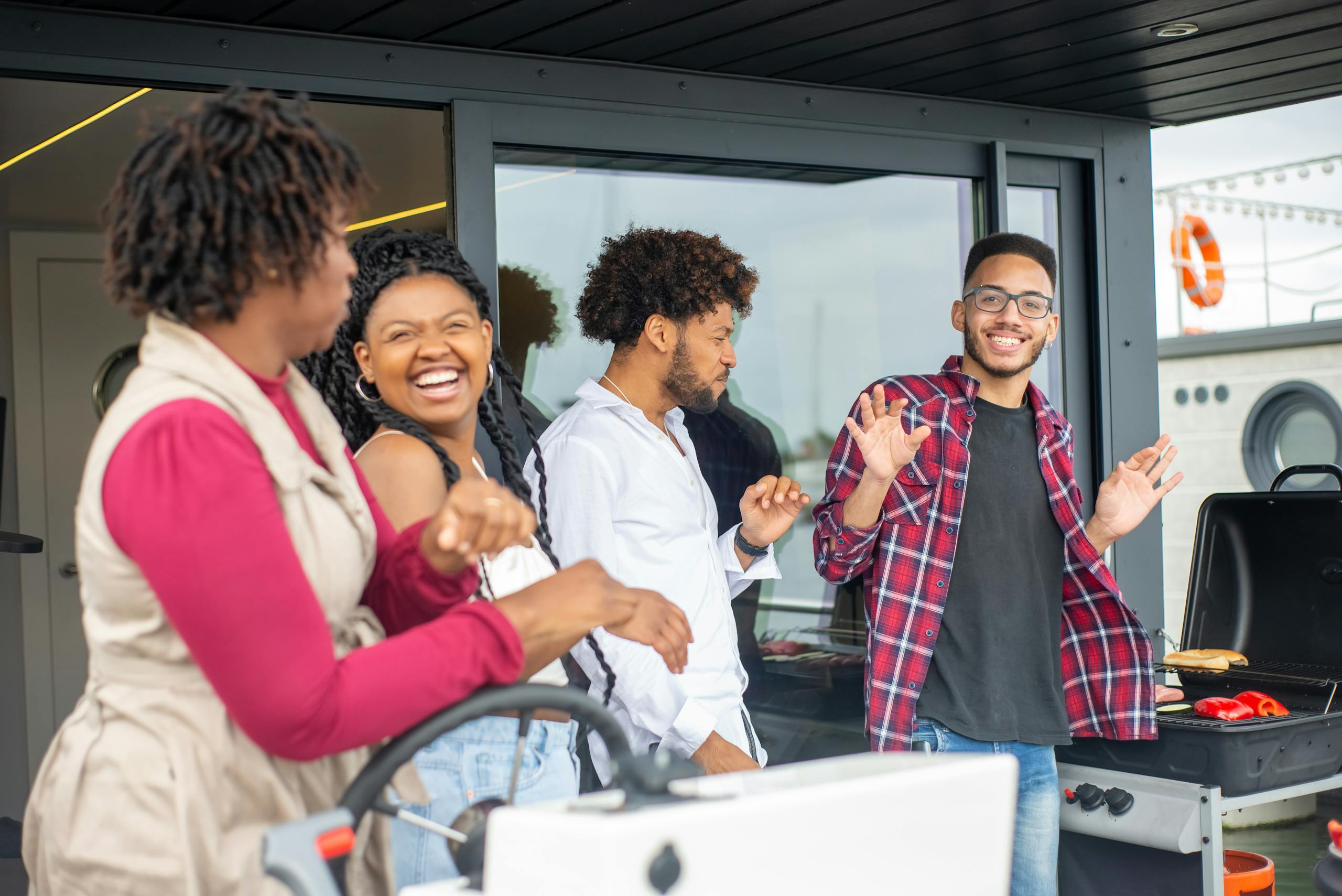 Group of friends laughing and grilling together outdoors, enjoying a sunny day in Portugal.